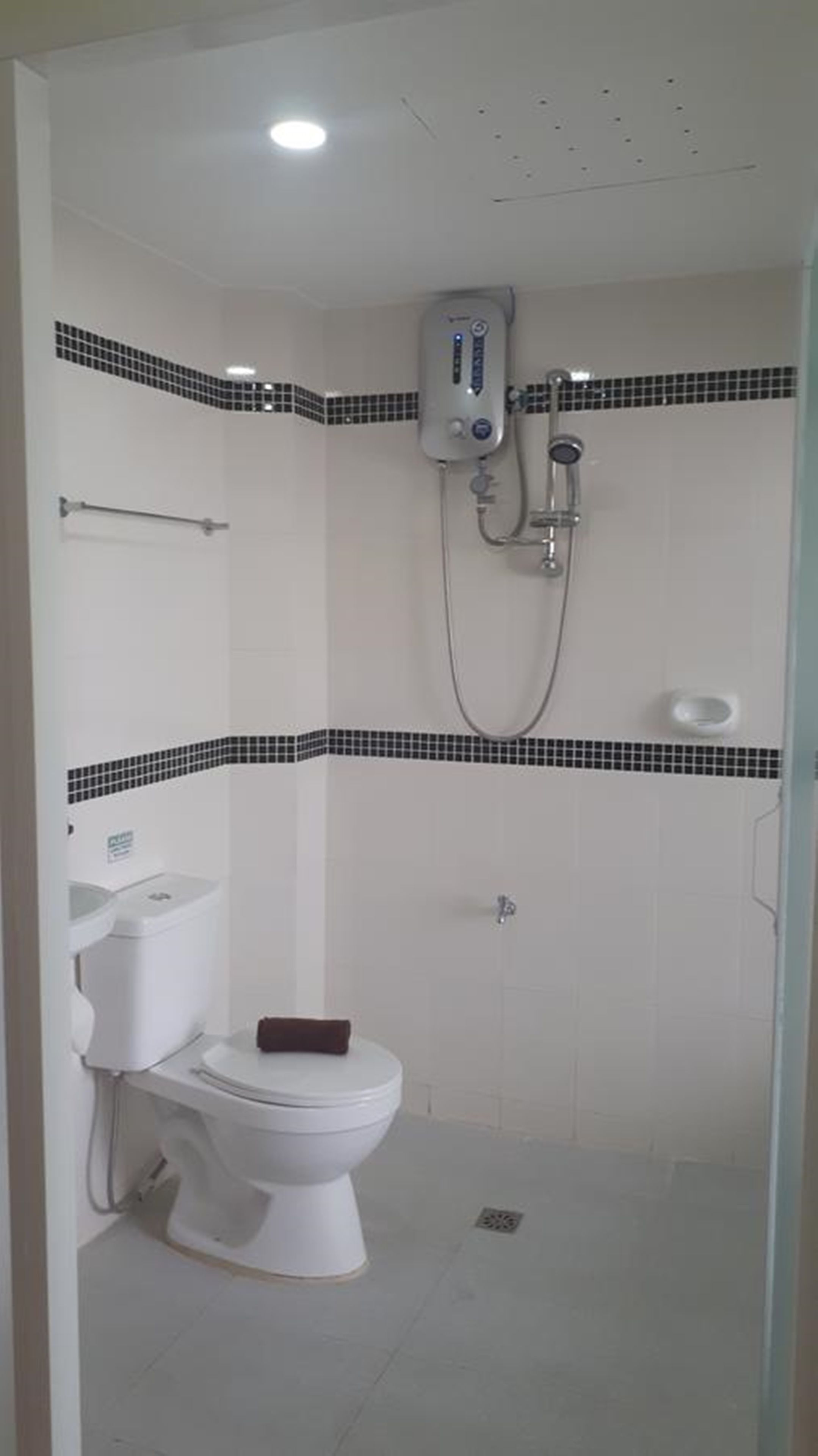 Un baño pequeño y funcional con inodoro, ducha y lavamanos.