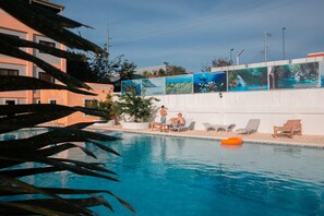Ein Schwimmbecken mit Liegestühlen und einer Holzterrasse.