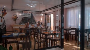 A dining area with a breakfast sign indicating the time from 6:30 AM to 10:00 AM. - Adams View Hotel (Moalboal)