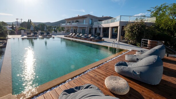 Ein Poolbereich mit Liegestühlen und einer Holzterrasse.