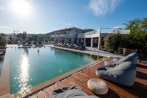 Una piscina al aire libre de temporada, sombrillas