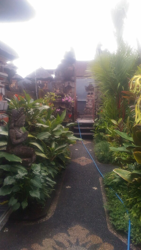 A pathway leading to a temple with steps and a statue.