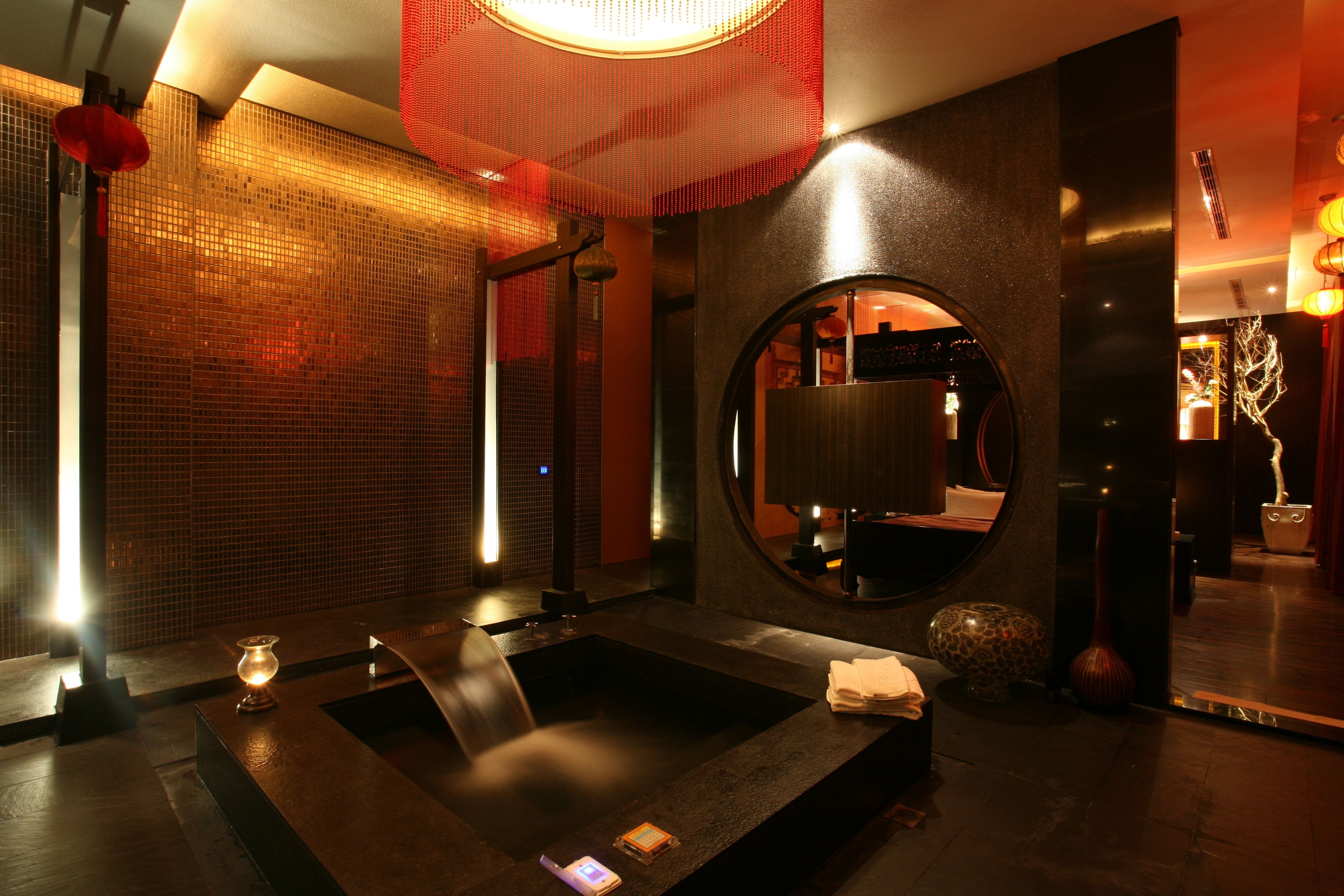 A modern bathroom with a large mirror, a heated floor, and a small sink.