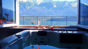 A room with a view of mountains and a balcony with drinks and flowers. - Casa Osmanto I: A cozy and welcoming apartment situated at a short distance from the shores of Lake Como, with Free WI-FI. (Domaso)