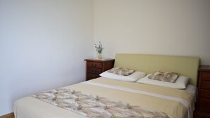 A bedroom with a bed, a nightstand, and a dresser.