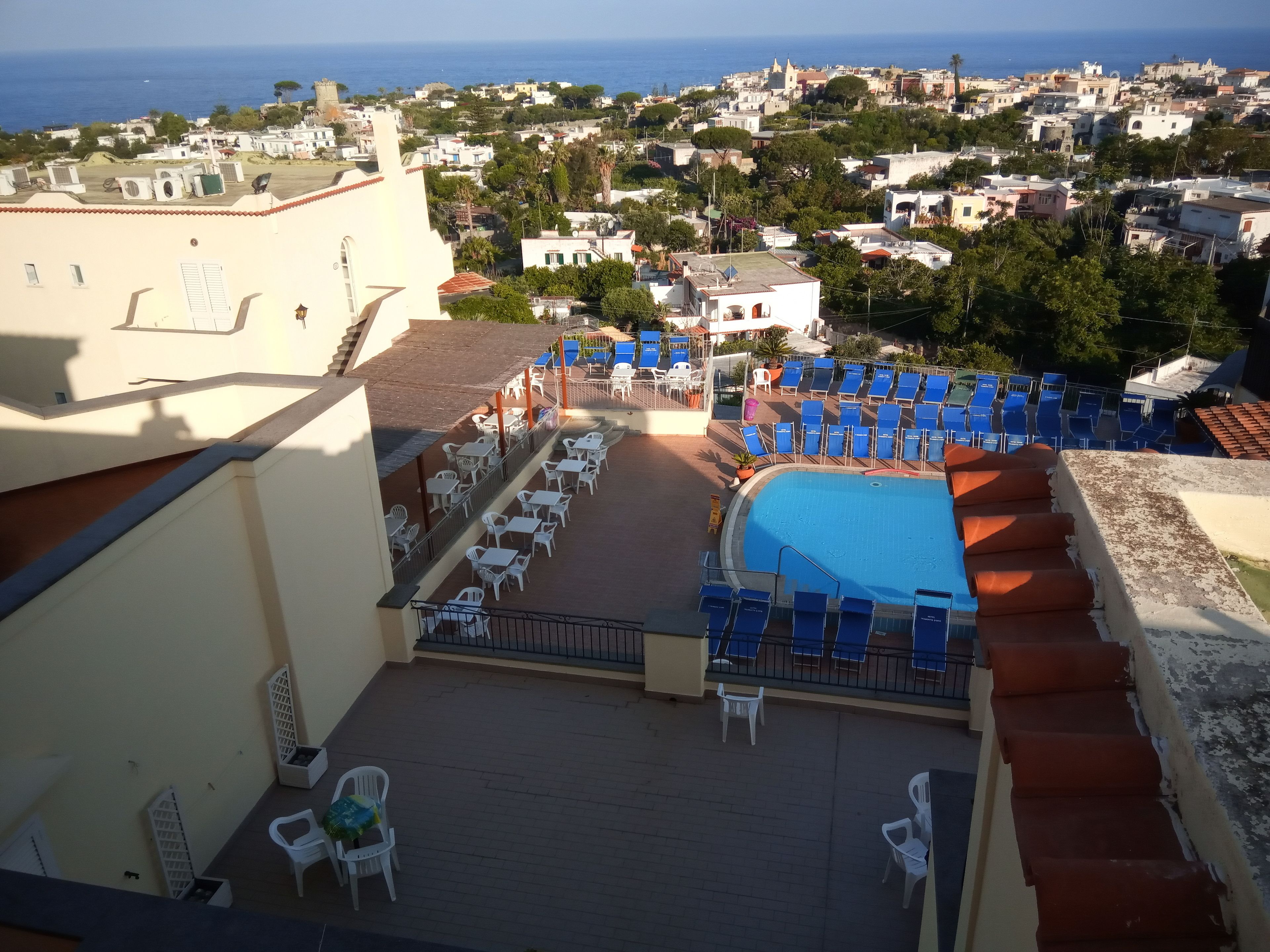 A rooftop pool area with blue lounge chairs and a swimming pool.