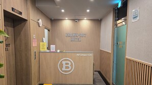 A reception area with a wooden panel wall, a reception desk, and a sign that reads "BROWN-DOT HOTEL". - Browndot Hotel Gwangju Hanam Branch (Gwangju)
