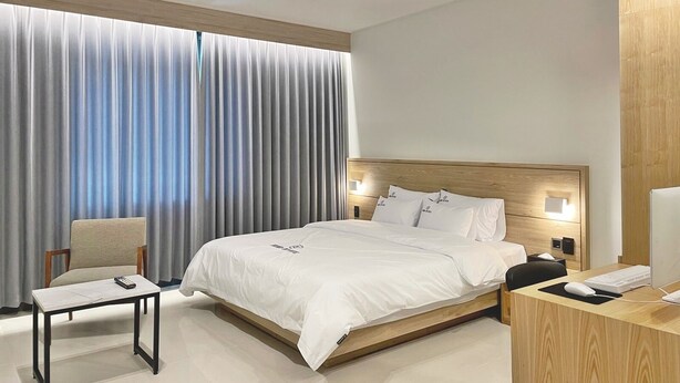 A modern hotel room with a large bed, a desk with a computer, a chair, and a window with curtains. - Browndot Hotel Gwangju Hanam Branch (Gwangju)