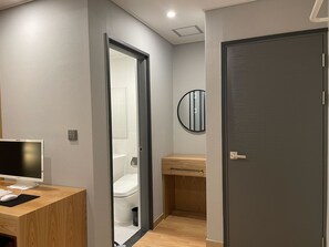 A modern bathroom with a toilet, sink, and mirror.