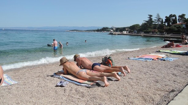 A beach with people sunbathing, a pool, and a clear sky. - Apartment Dory (Malinska-Dubasnica)