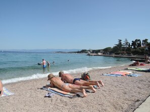 A beach with people sunbathing, a pool, and a clear sky. - Apartment Dory (Malinska-Dubasnica)