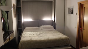 A compact room with a bed, a desk, and a wardrobe. - Lovely studio apartment within walking distance of the center of Chiesa Valmalenco (Chiesa in Valmalenco)