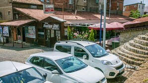 A building with a sign for 'Boutique Otel' and a cafe. There are parked cars in front. - Carsi Pansiyon (Amasra)