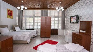 A hotel room with two beds, a wardrobe, a desk, and a television. - Carsi Pansiyon (Amasra)