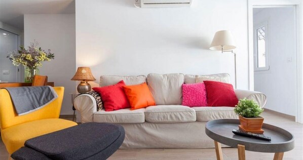 Relax in this stylish living room with a sofa, side table, and potted plant.