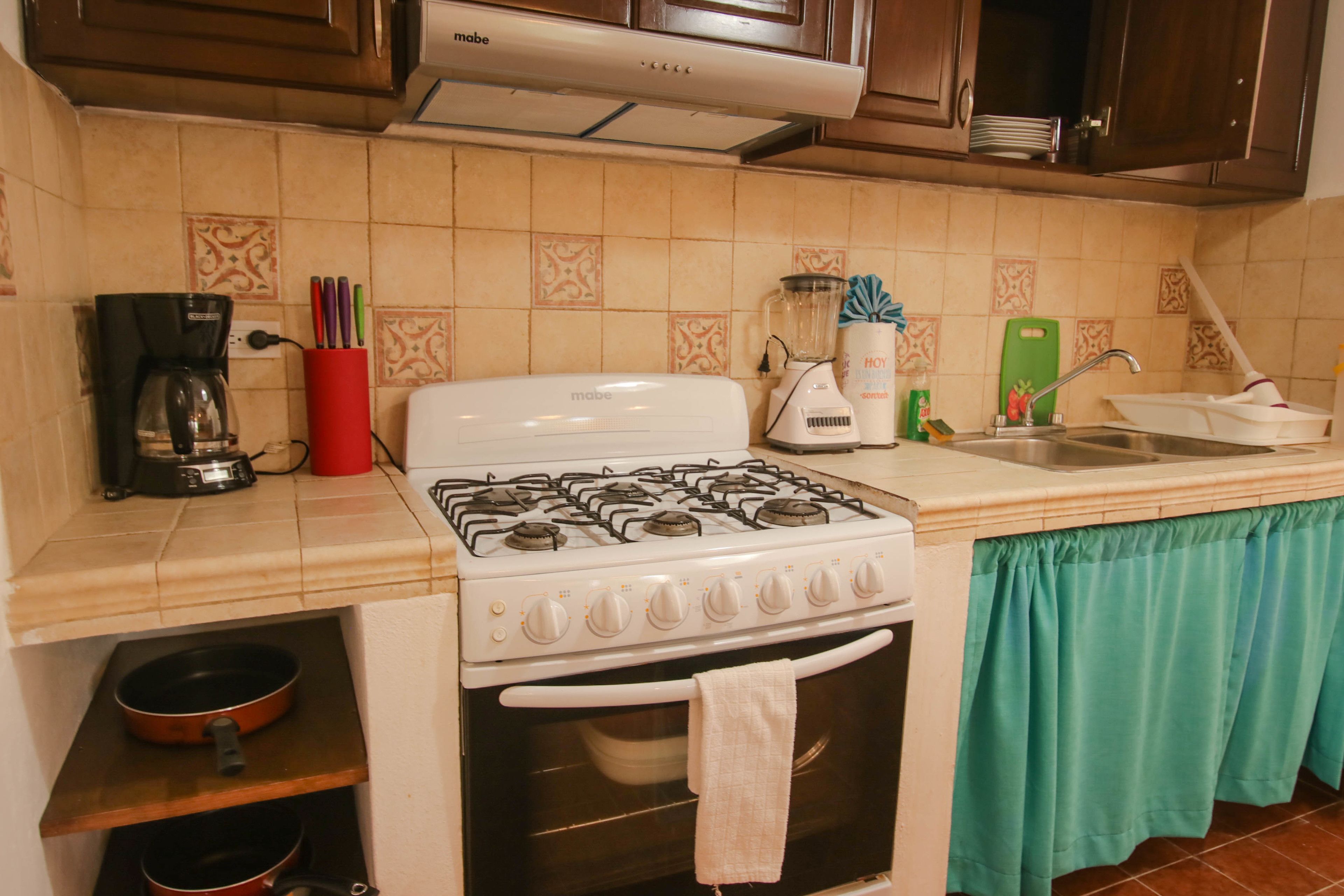 A kitchen with a stove, oven, sink, and various kitchen appliances.