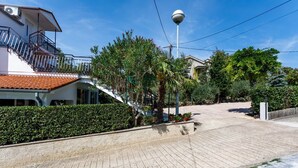 Ein Wohngebiet mit befestigter Auffahrt, einer Treppe, die zu einem Balkon führt, und einer Straßenlaterne.