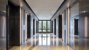 A modern, spacious hallway with reflective floors and large windows. - Alva Hotel By Royal (Sha Tin)