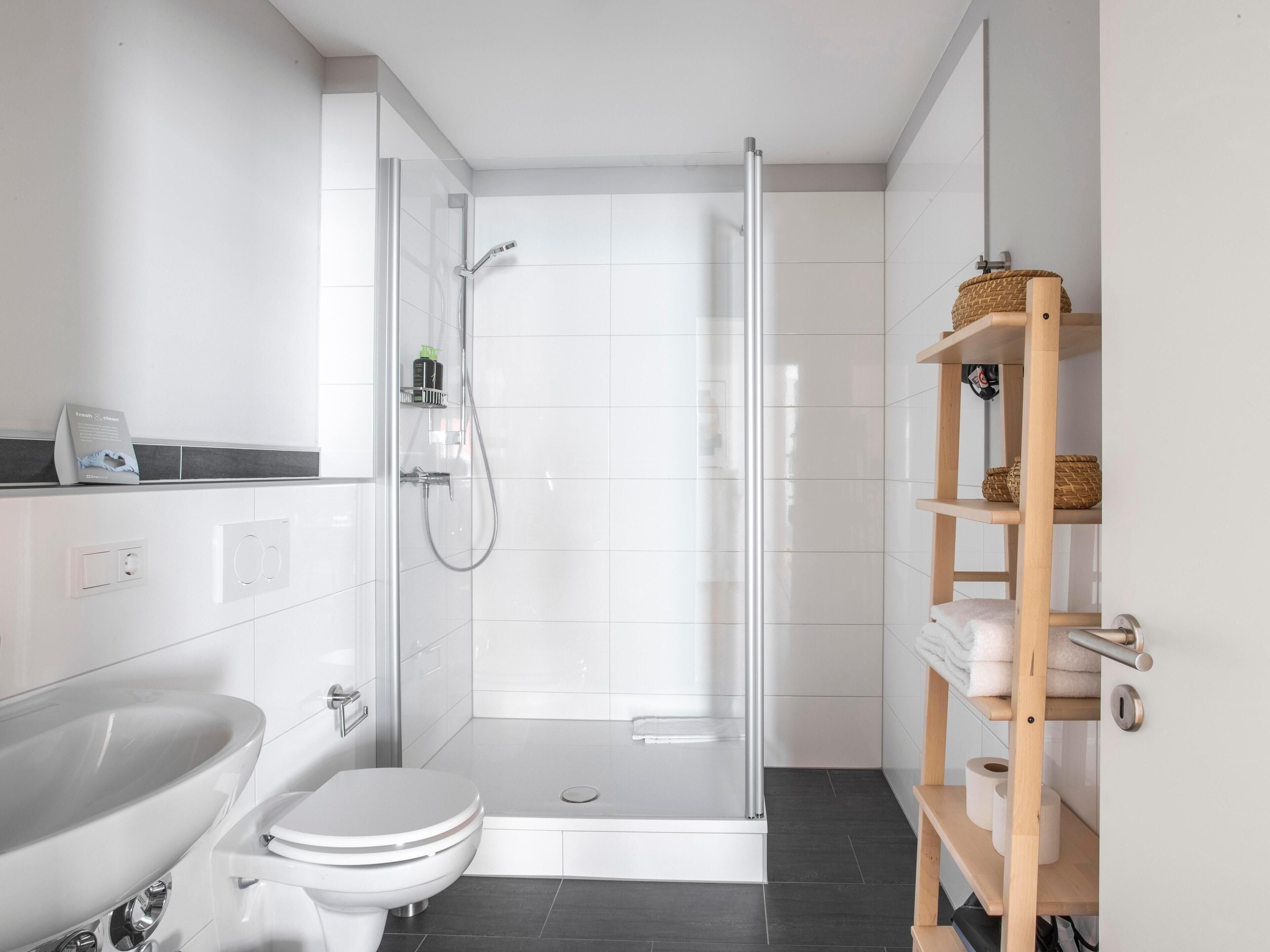 Une salle de bain moderne équipée d’une douche, de toilettes et d’un lavabo.
