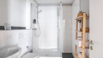 Une salle de bain moderne équipée d’une douche, de toilettes et d’un lavabo.