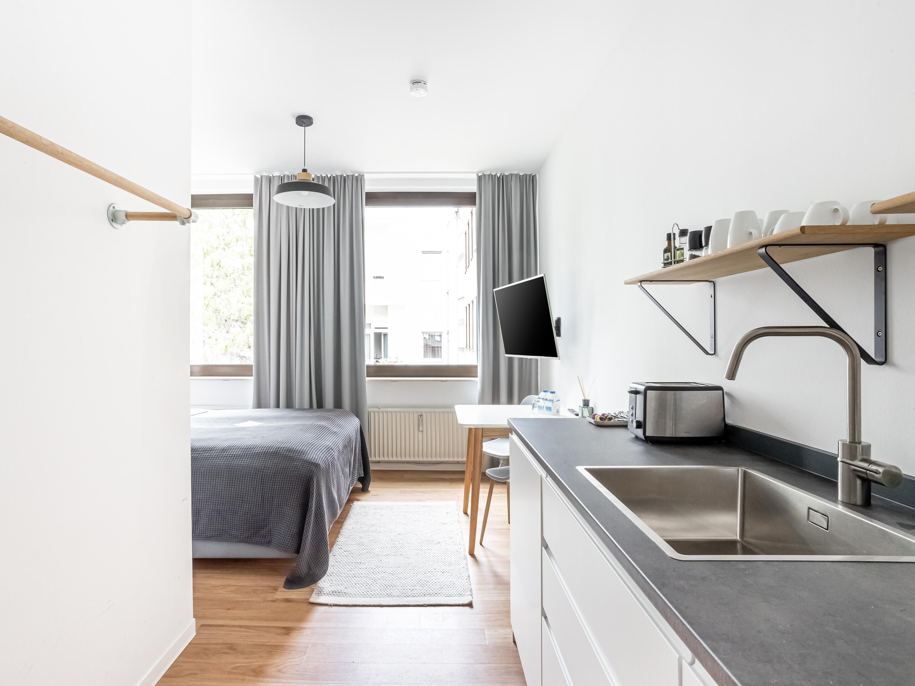 Een moderne keuken met een ingebouwd spoelbak, fornuis en een flatscreen televisie.