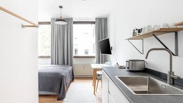 Een moderne keuken met een ingebouwd spoelbak, fornuis en een flatscreen televisie.