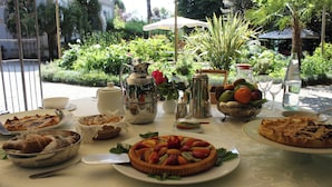 Mesa posta com diversos pratos e vista para um jardim.