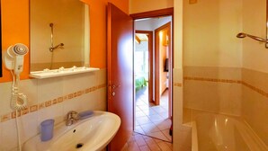 Une salle de bain avec un lavabo, un miroir et une douche.
