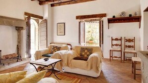 A cozy living room with a fireplace, a sofa, and a coffee table. - 3 bedroom villa (8 sleeps) with private pool in Garfagnana (55030 Villa Collemandina)