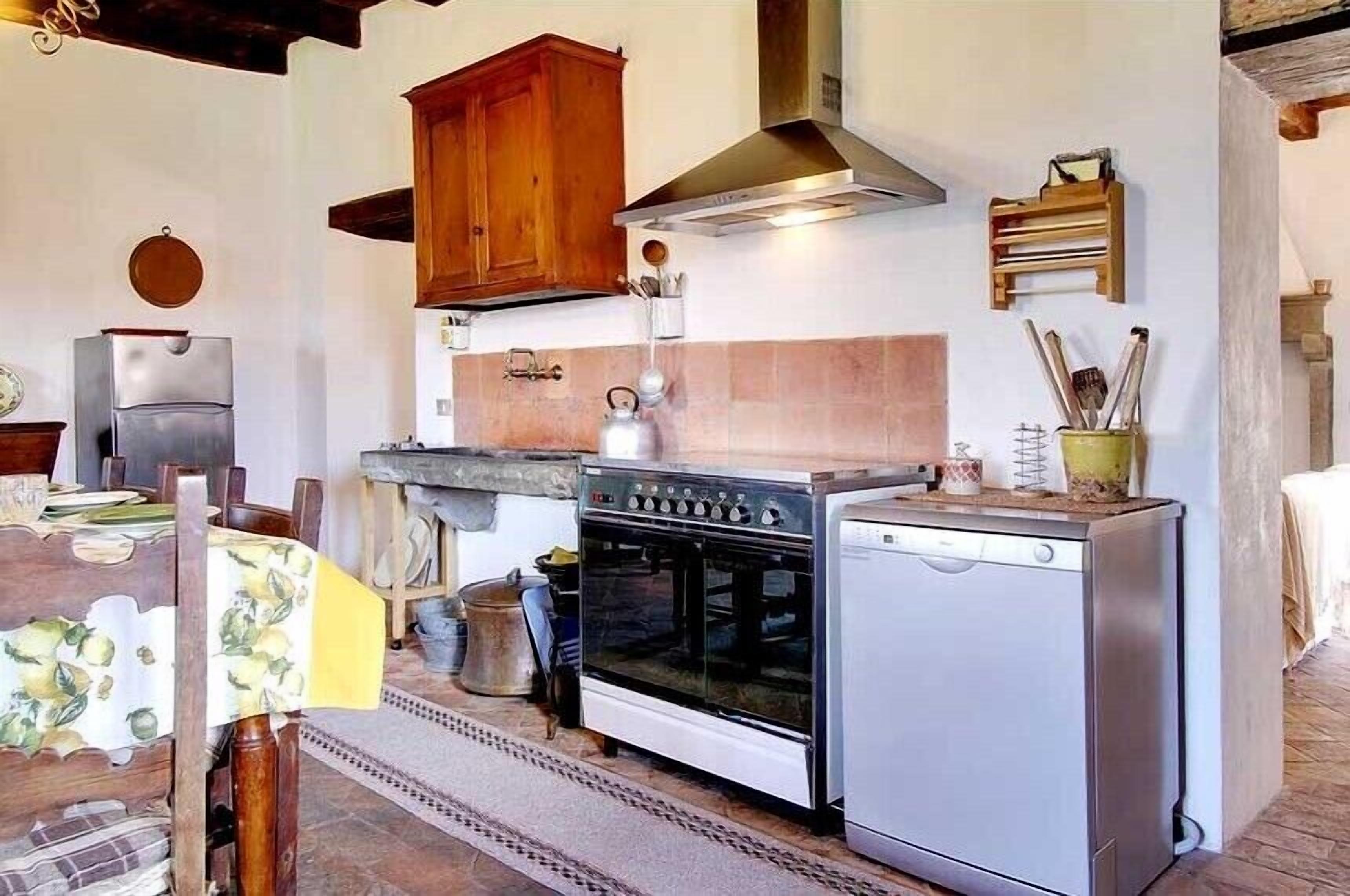 A compact kitchen with wooden cabinets, a stove, and a dishwasher.