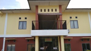 A two-story building with a balcony on the upper floor, a signboard in front, and a small entrance. - Penginapan Syariah (Pekanbaru)