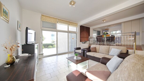 A spacious living room with a sofa set, a coffee table, and a television. - Villa Adria (Zadar)