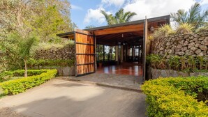 A modern building with a wooden entrance and a stone wall. - Monteverde Panoramic House (Monteverde)