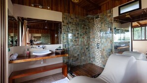 A modern bathroom with a wooden ceiling, a glass shower enclosure, a white sink, and a bench. - Monteverde Panoramic House (Monteverde)