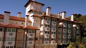 Un edificio de varios pisos con un estilo arquitectónico tradicional, que presenta una fachada simétrica con ventanas distribuidas uniformemente y elementos decorativos.