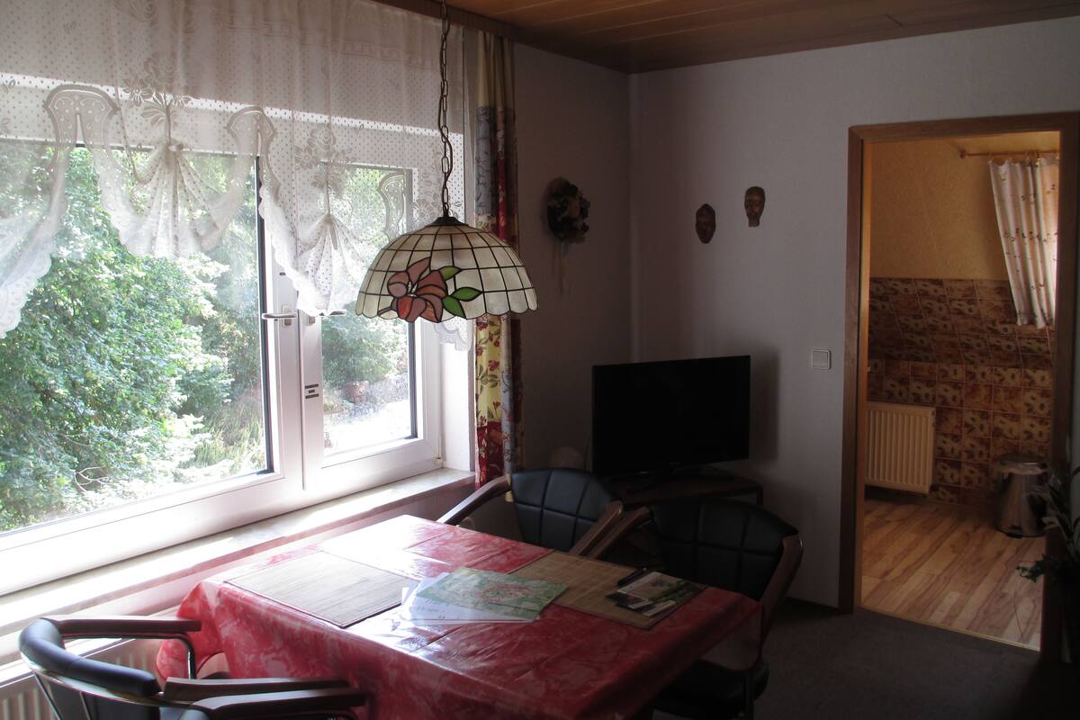 Comedor con mesa, sillas y televisor.