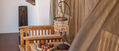 A wooden dining table with a woven bench and a wicker ottoman.