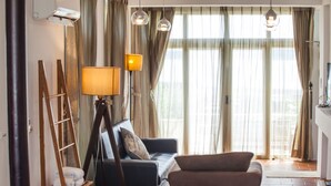 A living room with a sofa, a chair, a lamp, and a ladder. - Summer Ya B&B (Huxi)