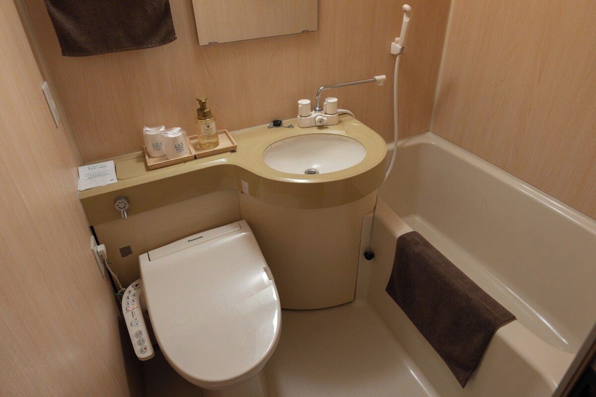 A compact bathroom with a toilet, sink, and bathtub.