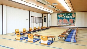 A room with tatami mats, wooden furniture, and a traditional Japanese mural. - Akatsuki Inn Daitoku (Choshi)