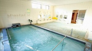 An indoor swimming pool with a tiled floor, a ladder, and a bench. - Akatsuki Inn Daitoku (Choshi)