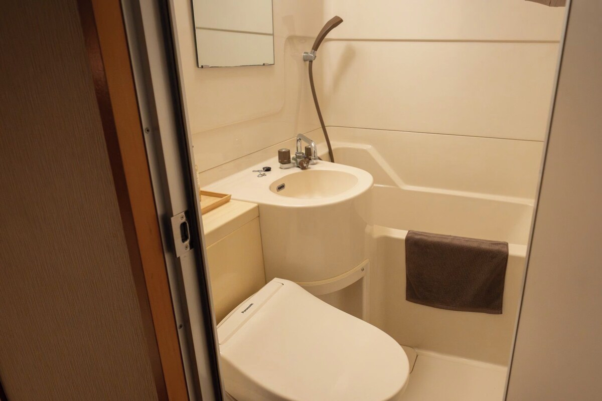 A compact bathroom with a toilet, sink, and bathtub.