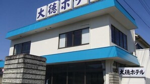 A hotel with a blue and white facade, a stone base, and large windows. - Akatsuki Inn Daitoku (Choshi)
