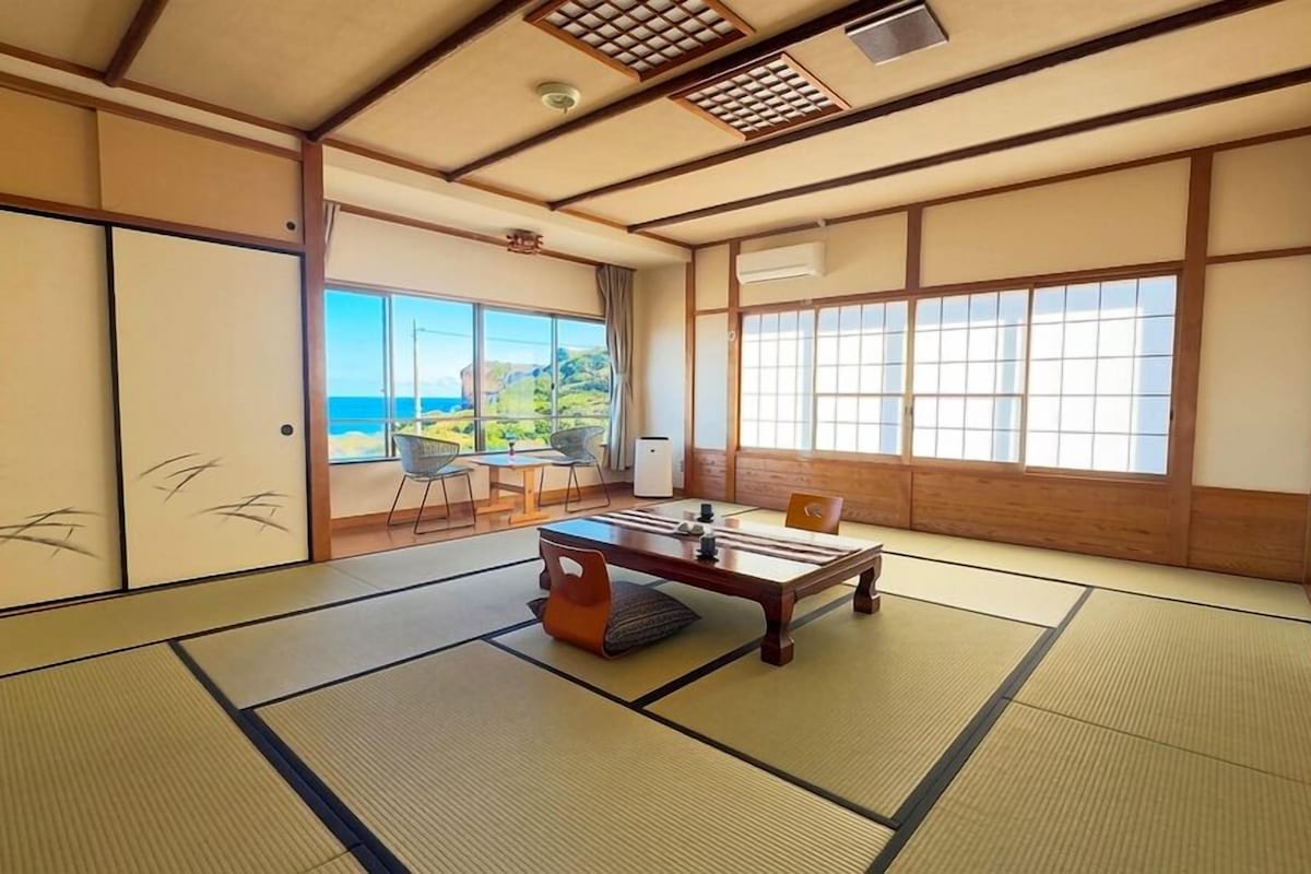 A traditional Japanese room with tatami flooring, a low table, and sliding doors.
