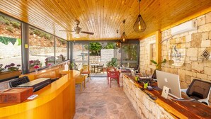 A reception area with a wooden ceiling, stone walls, and a desk with computers. - Hotel Luna Kas (Kas)