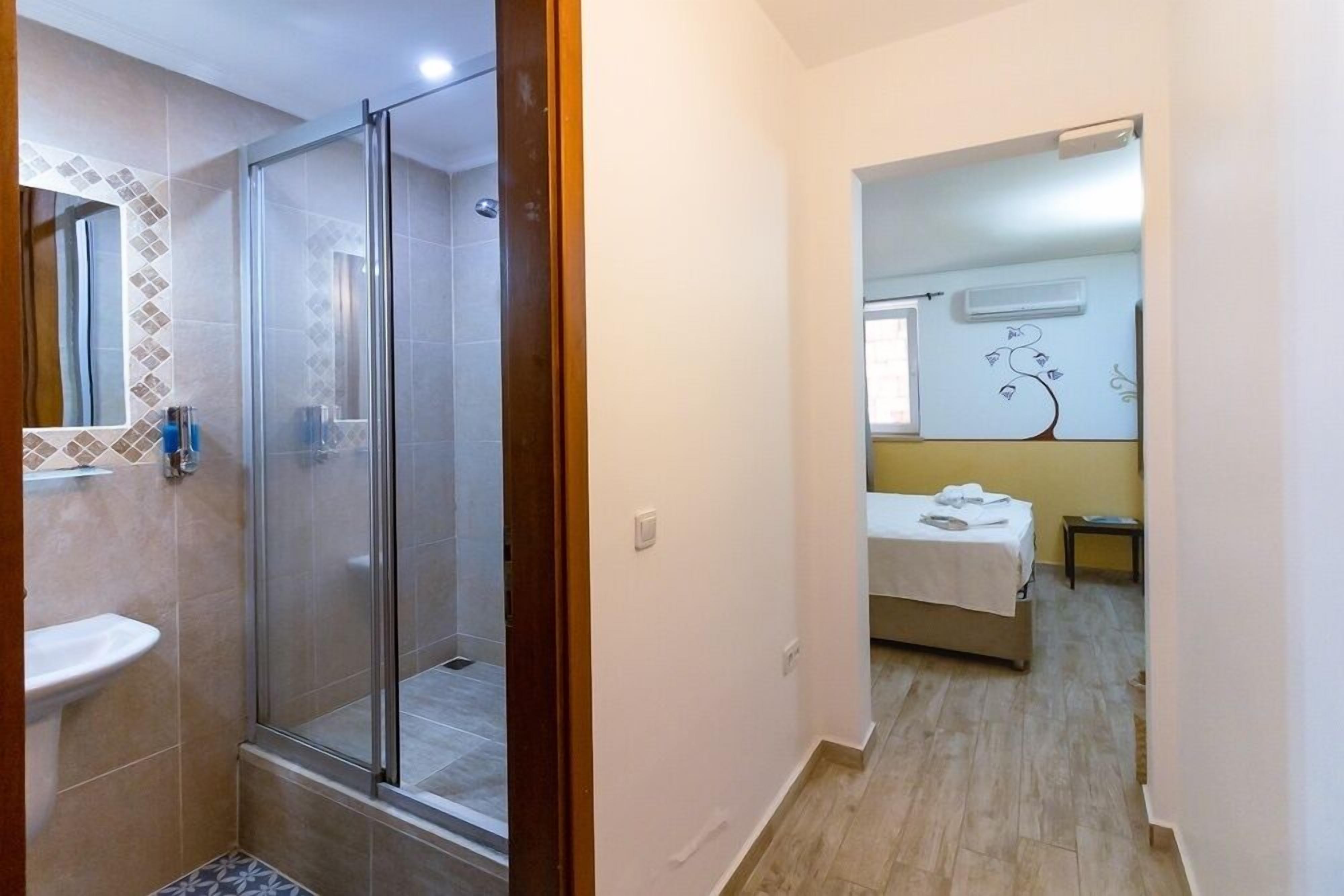 Une salle de bain avec une douche à parois de verre, un lavabo et un miroir.