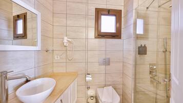 Un baño moderno con lavamanos, espejo, inodoro y ducha.