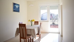 Un comedor con una mesa, sillas y un jarrón con flores.