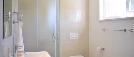 Departamento clásico | Baño | Regadera, toallas, jabón, shampoo