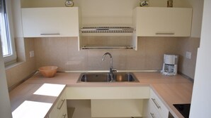 Cocina moderna con pileta, encimera y alacenas.